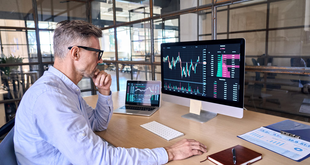 איש עסקים יושב במשרד מודרני מול מסכי נתונים - עבור תהליך SOLUTION